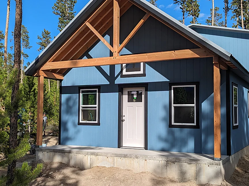 Blue Sunny Side shell with timber accents and covered porch
