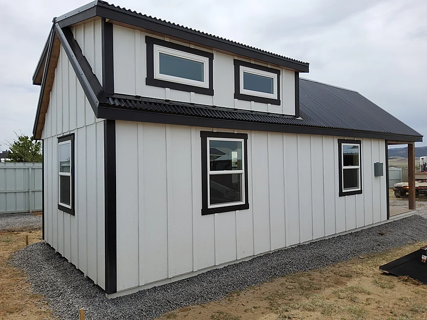 White Cabin shell with double dormers and black trim