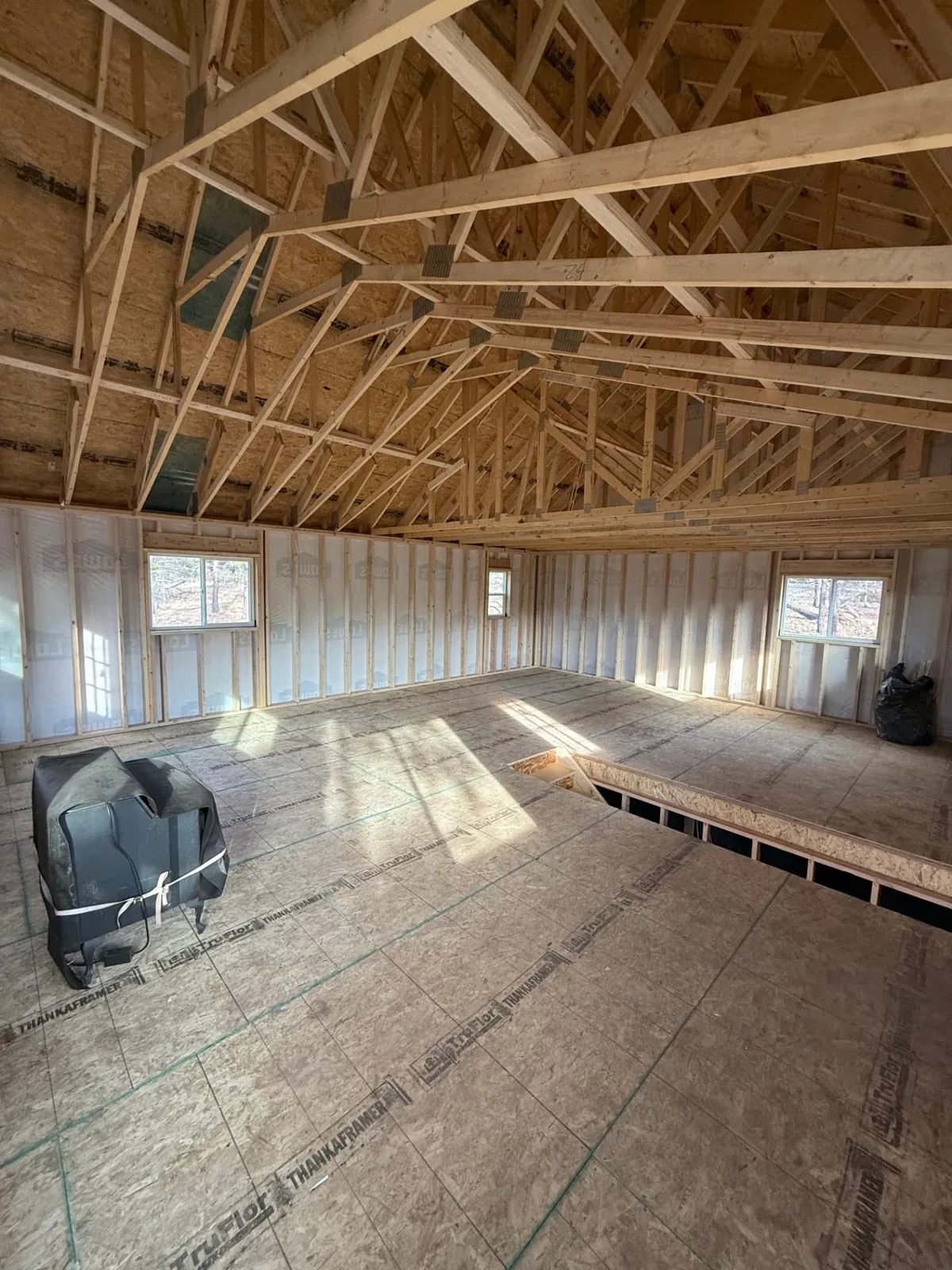 Upper level of the Fort Garland homeshell with exposed roof trusses and subfloor