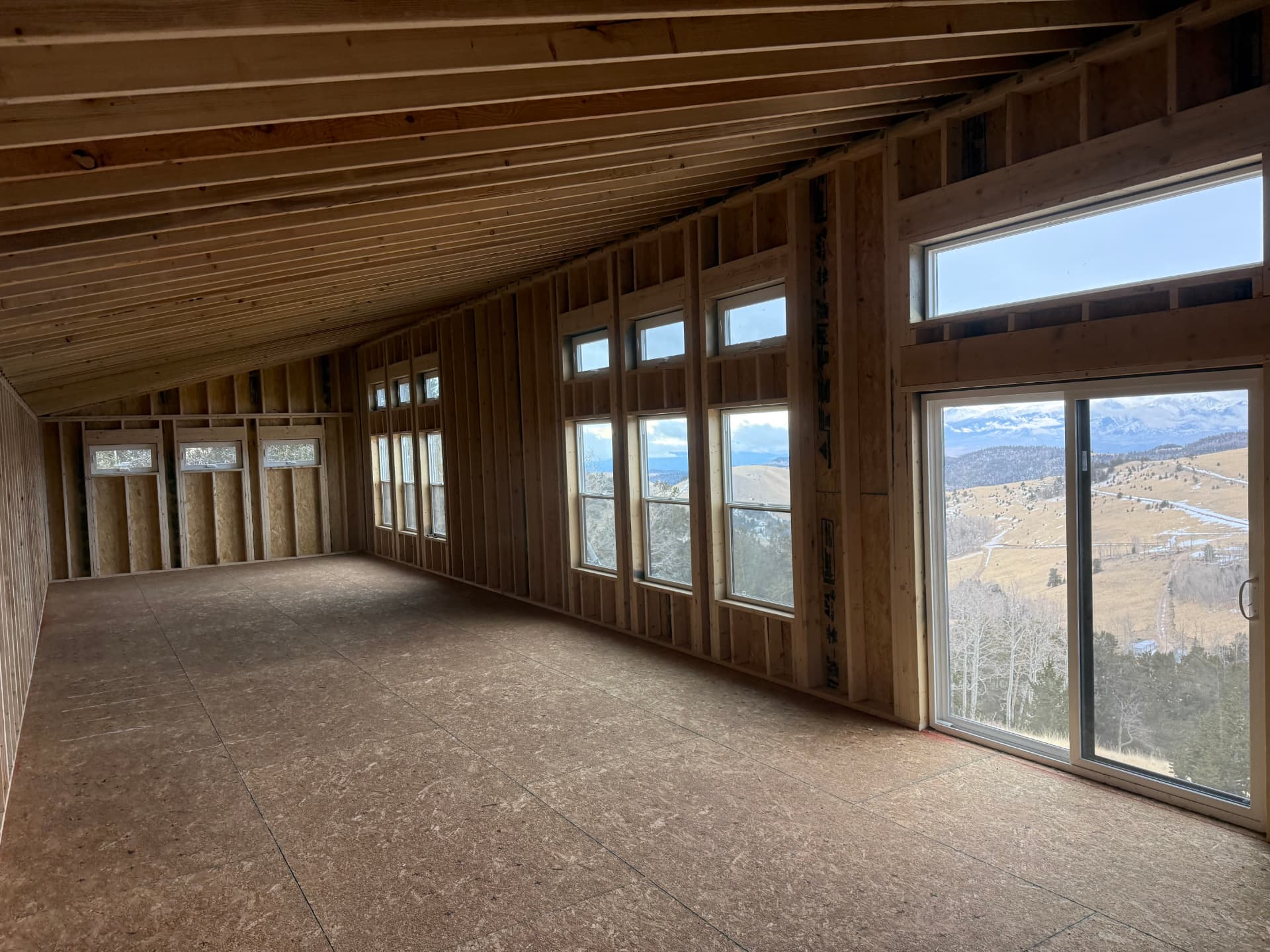 Interior framing of a Mountain Modern home shell with large windows overlooking Colorado mountains