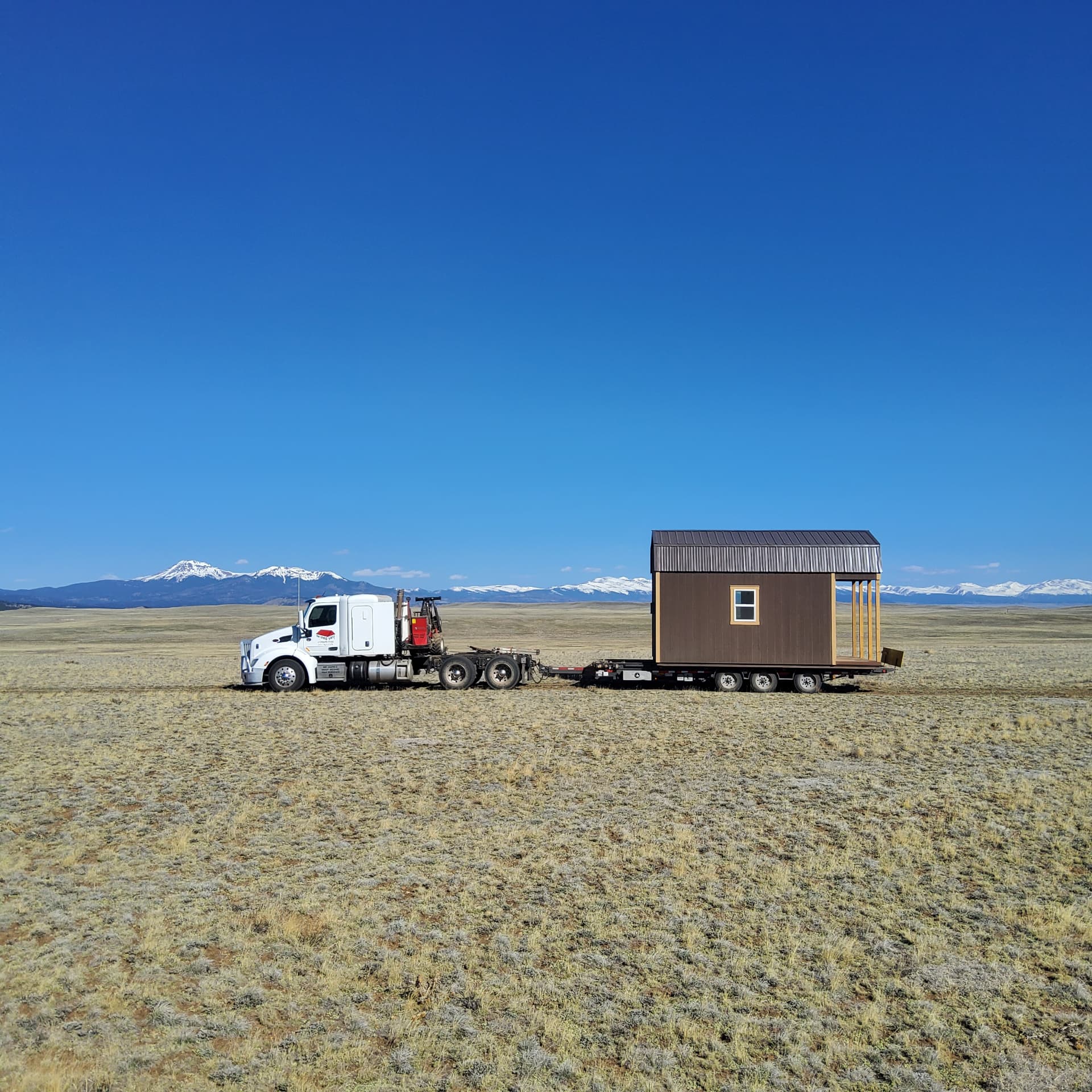 The Shed Yard truck and trailer delivering a fully assembled shed in Colorado
