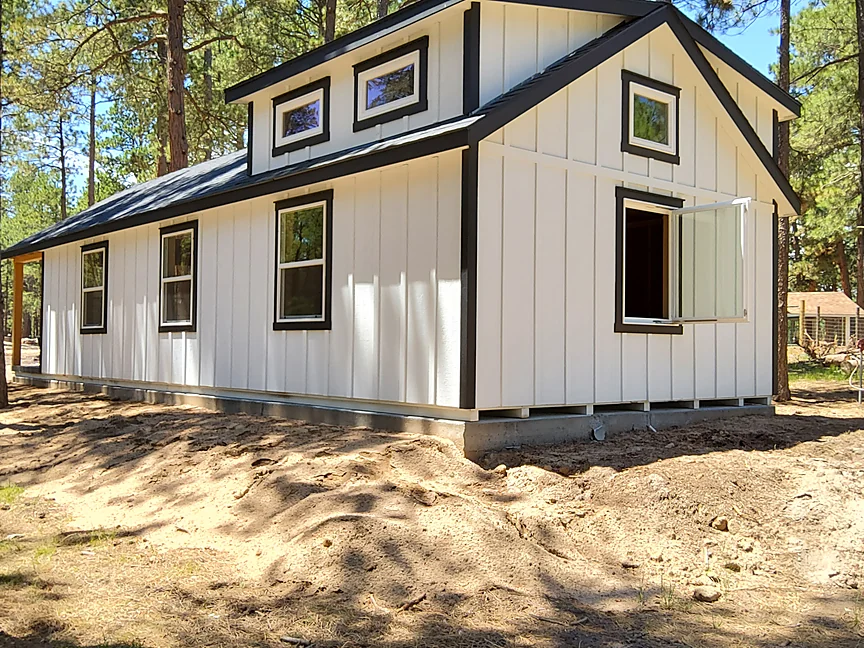 White board-and-batten Cabin shell with dormers