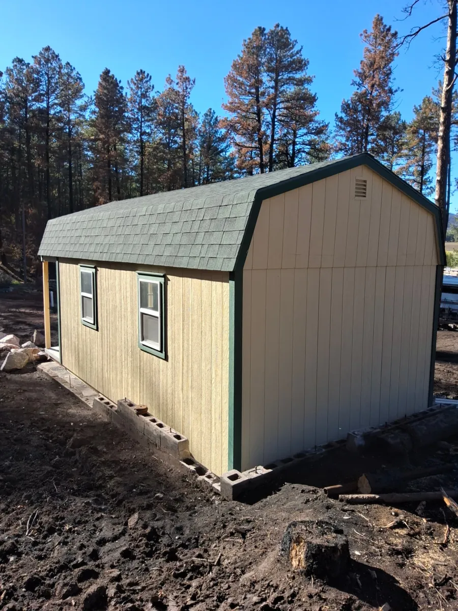 Rear and side view of a used 12x24 Hi Wall Barn with LP SmartSide siding and green trim in Beulah, Colorado