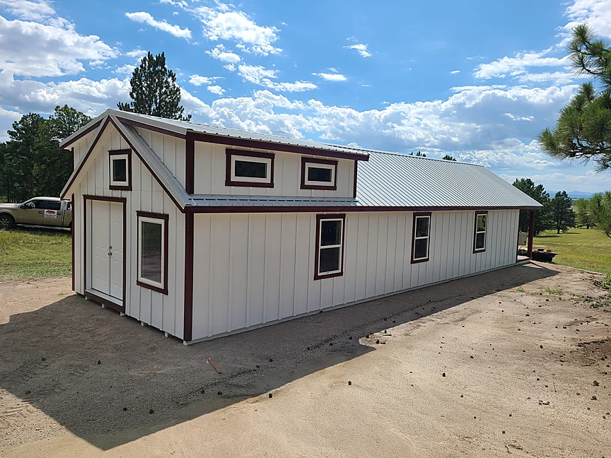 White Cabin shell with brown trim and metal roof