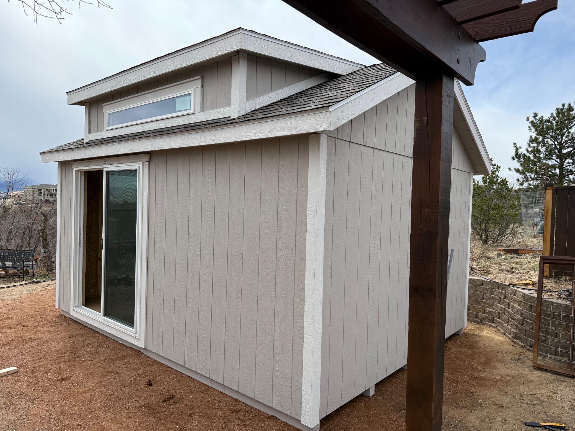 Light gray Colorado shed with vertical LP SmartSide siding and white trim