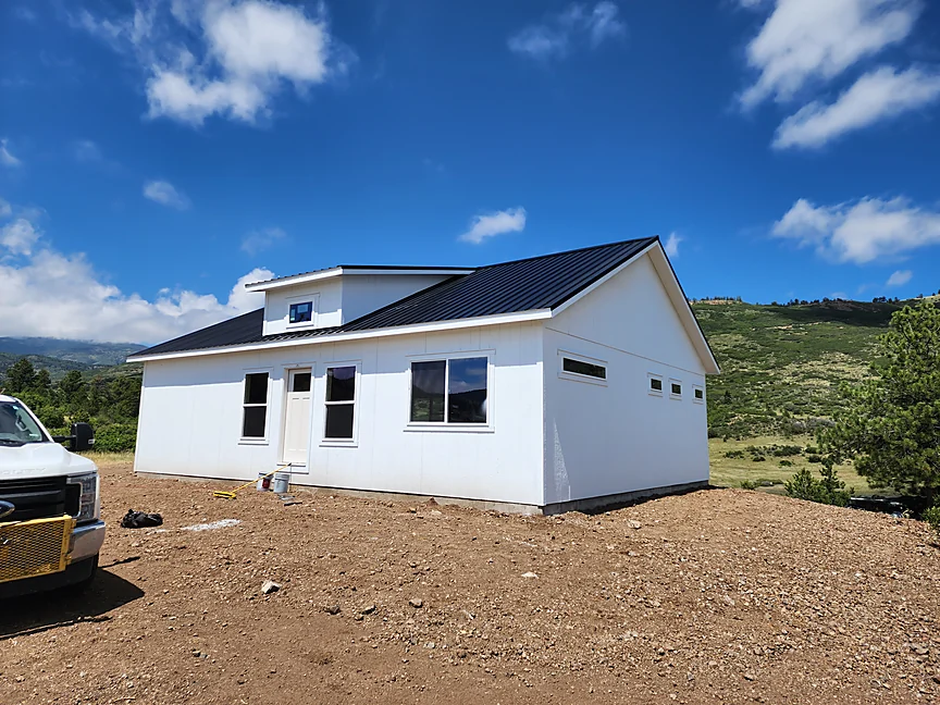 Sunny Side home shell with metal roof and white siding