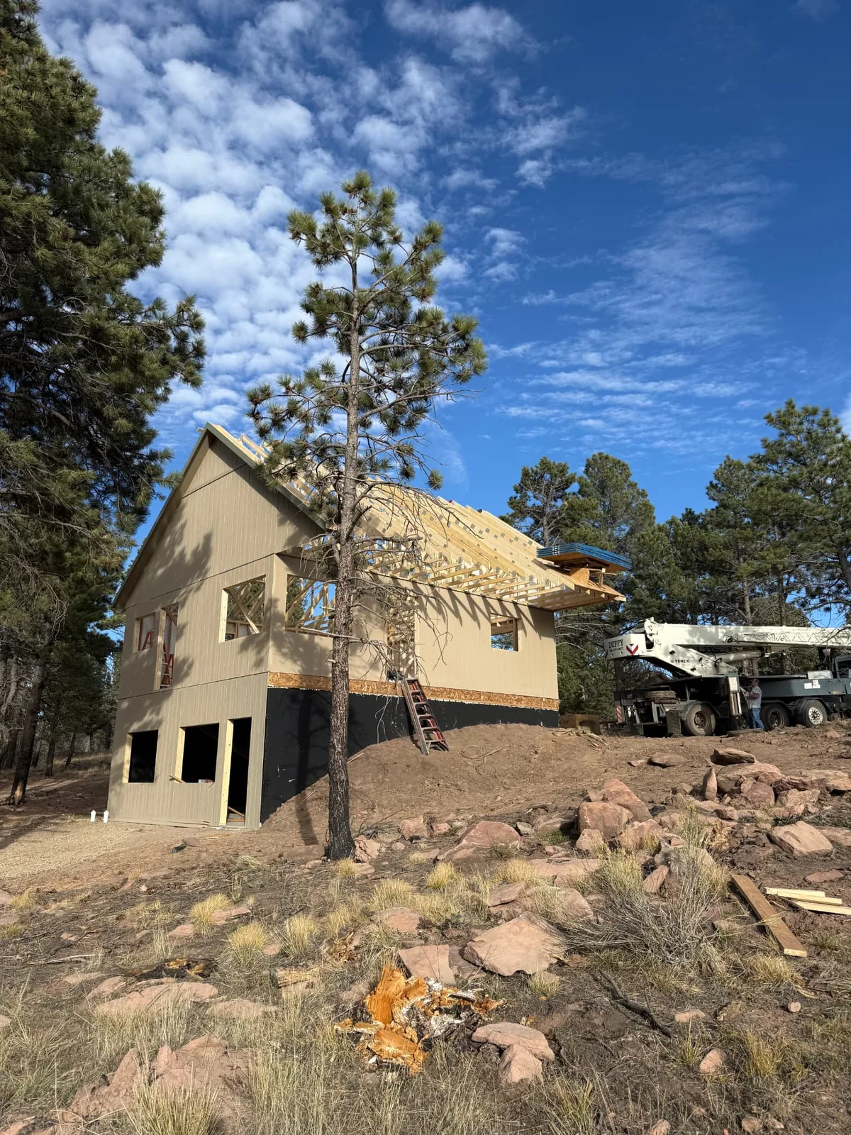 Crane setting roof trusses during construction of the Fort Garland homeshell