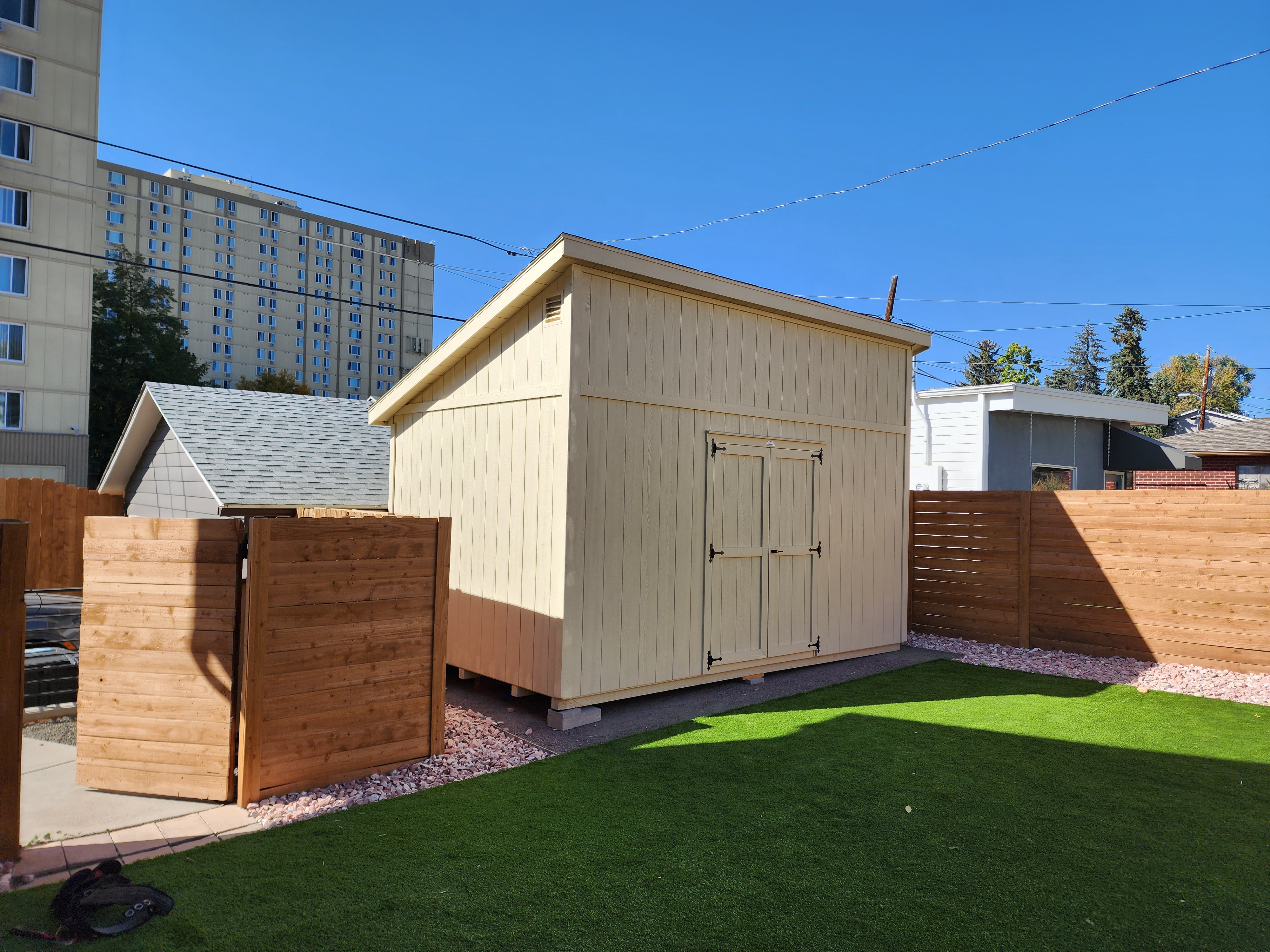 Backyard gym shed in a Denver Colorado city yard with wide double doors for moving gym equipment inside