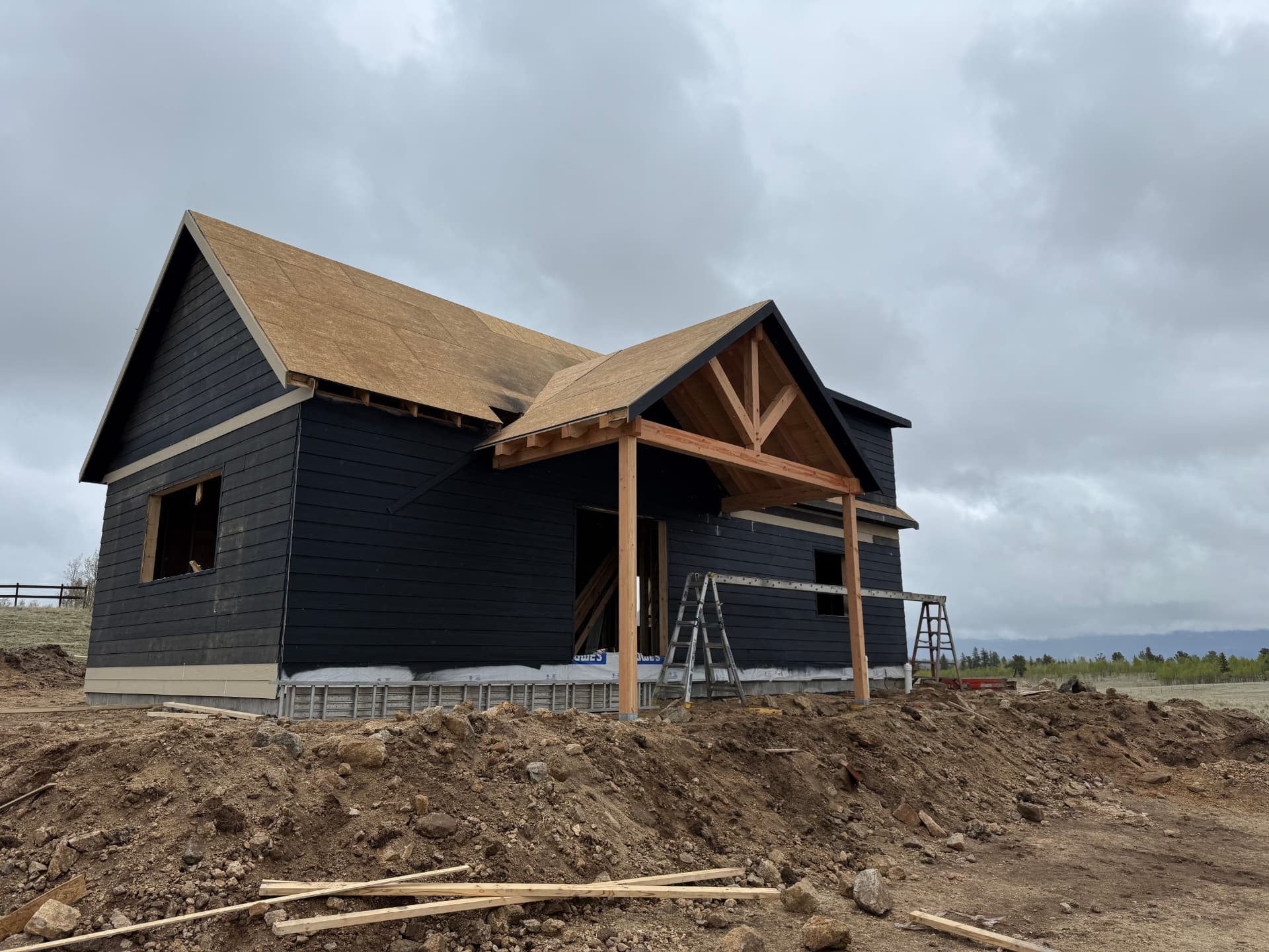 Timber frame covered porch and decked roof on a Sunny Side home shell in Park County, Colorado