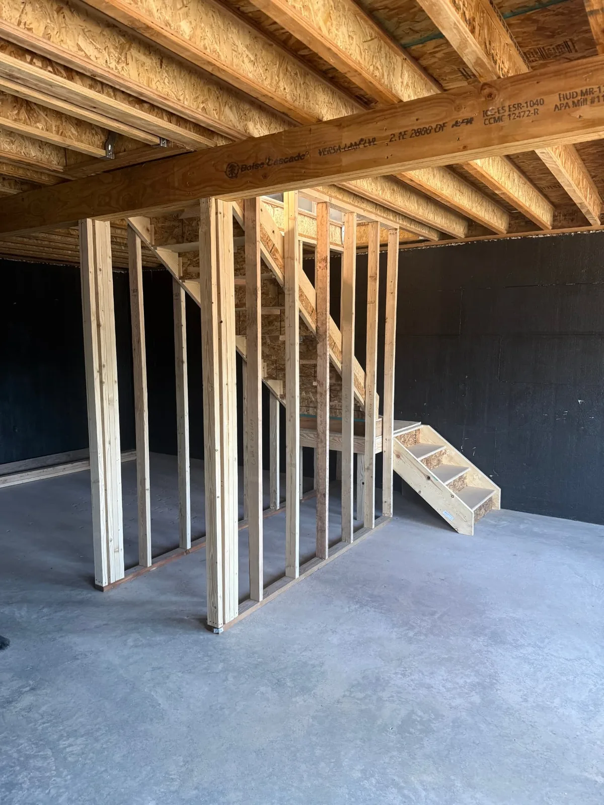 Framed stairs and concrete floor inside the Fort Garland homeshell walkout basement