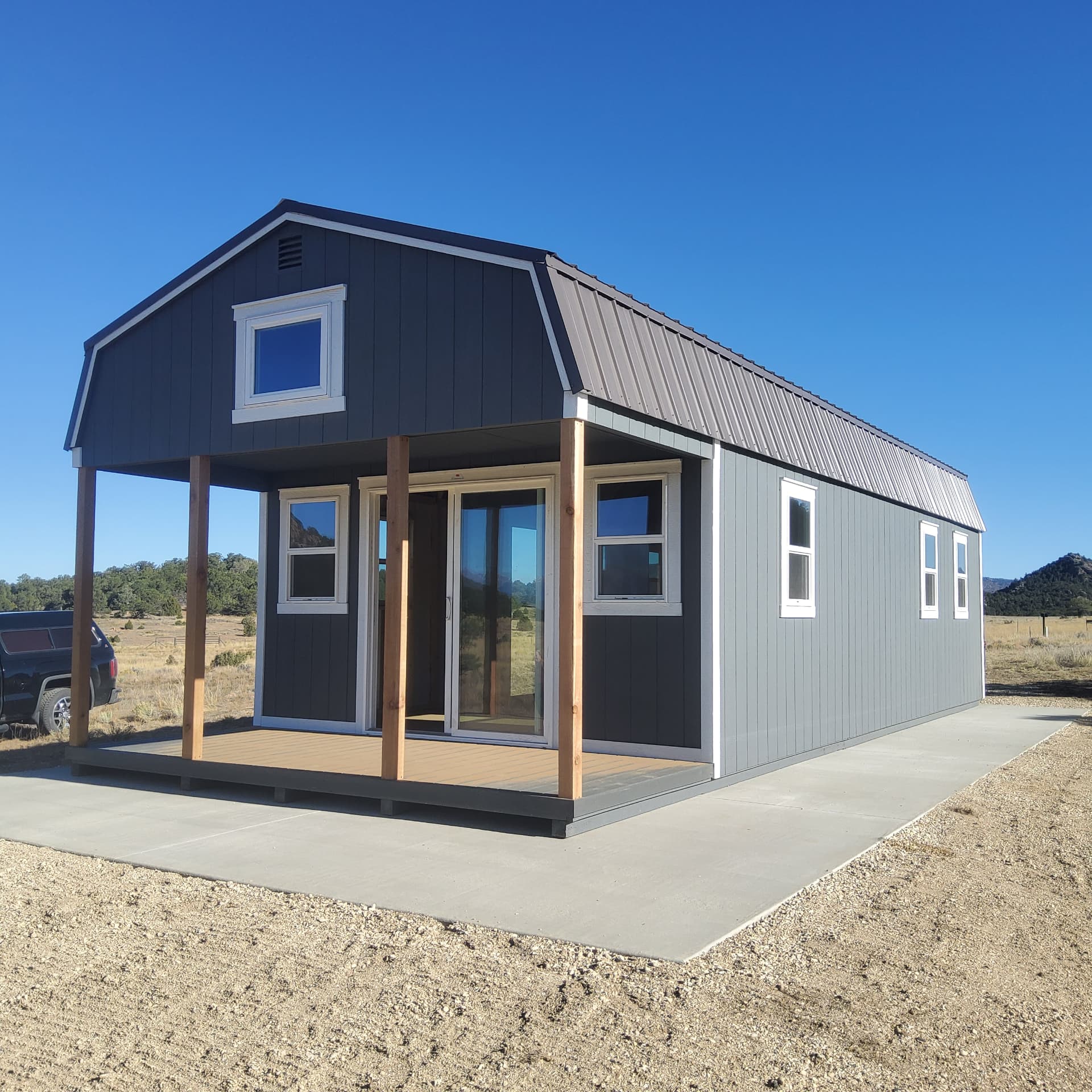 Hi-Wall lofted barn with covered porch and sliding glass door delivered in Colorado