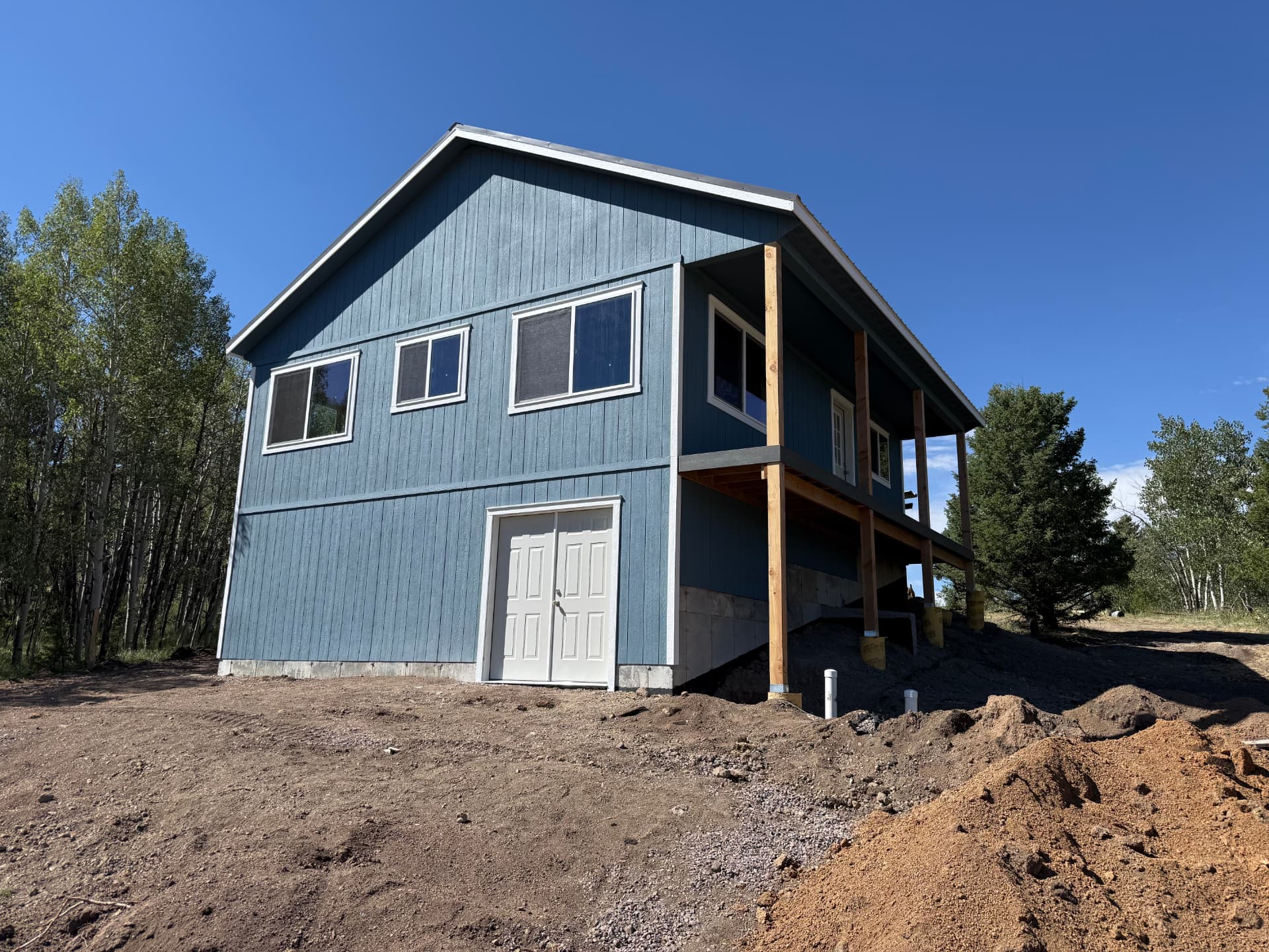 Two-story blue custom shed barn completed on a rural Colorado property with Turn-Key permit services
