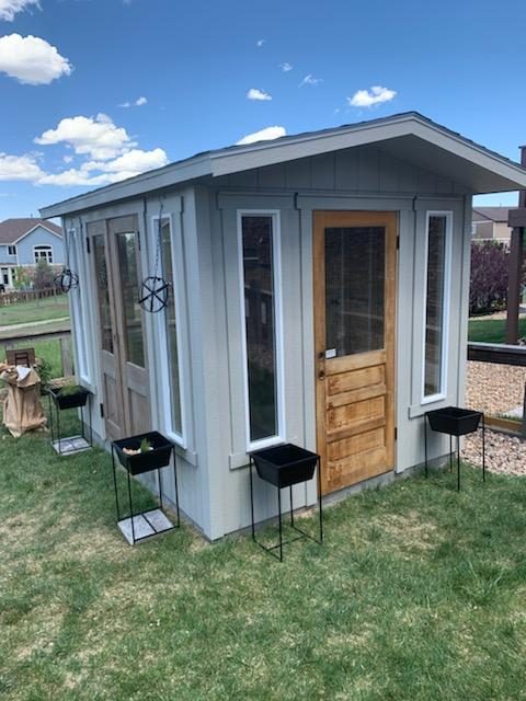 Exterior of a custom 8x10 Classic A-Frame She Shed in an Aurora, Colorado backyard, with wood door and tall windows