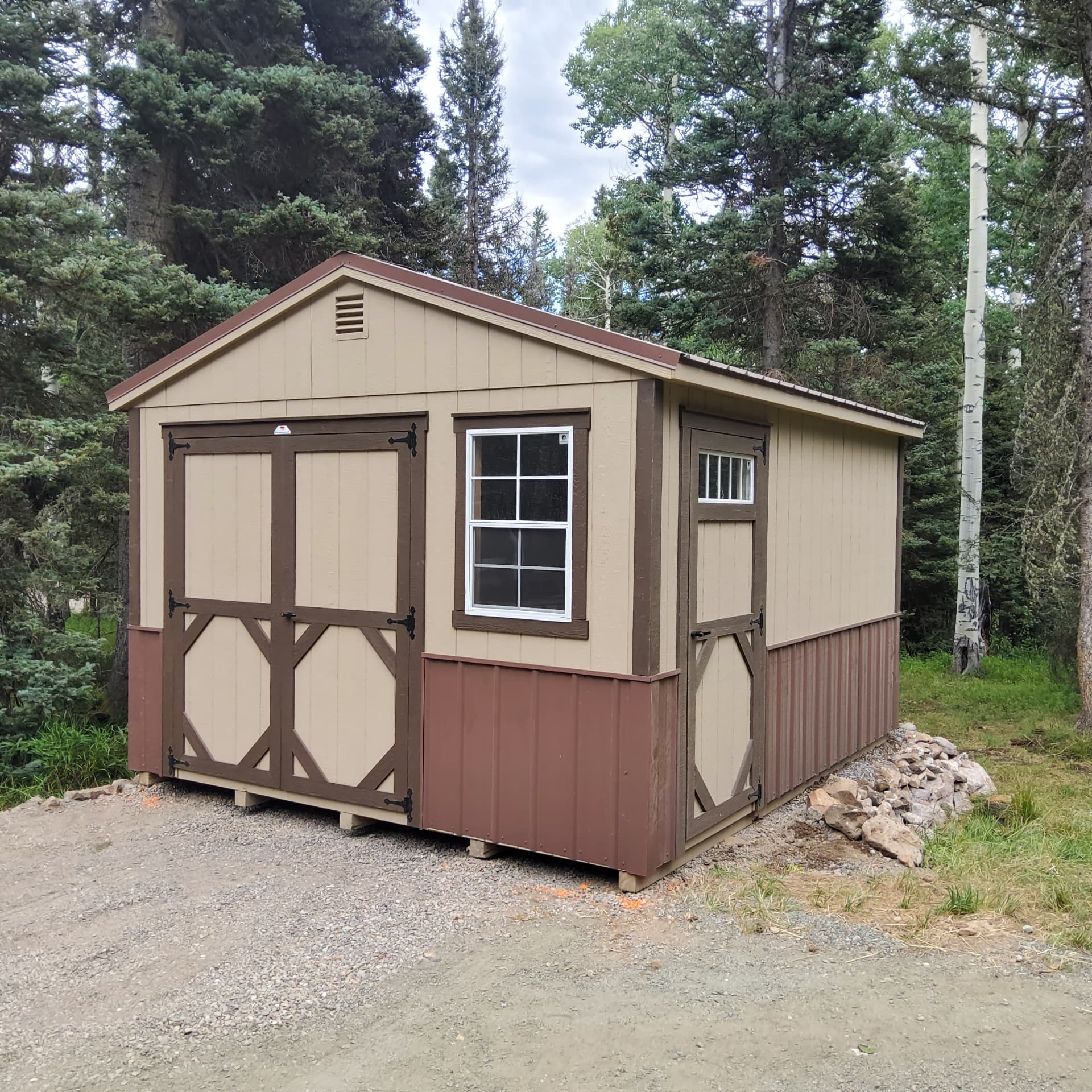 Colorado workshop shed with double doors and window set in a mountain property