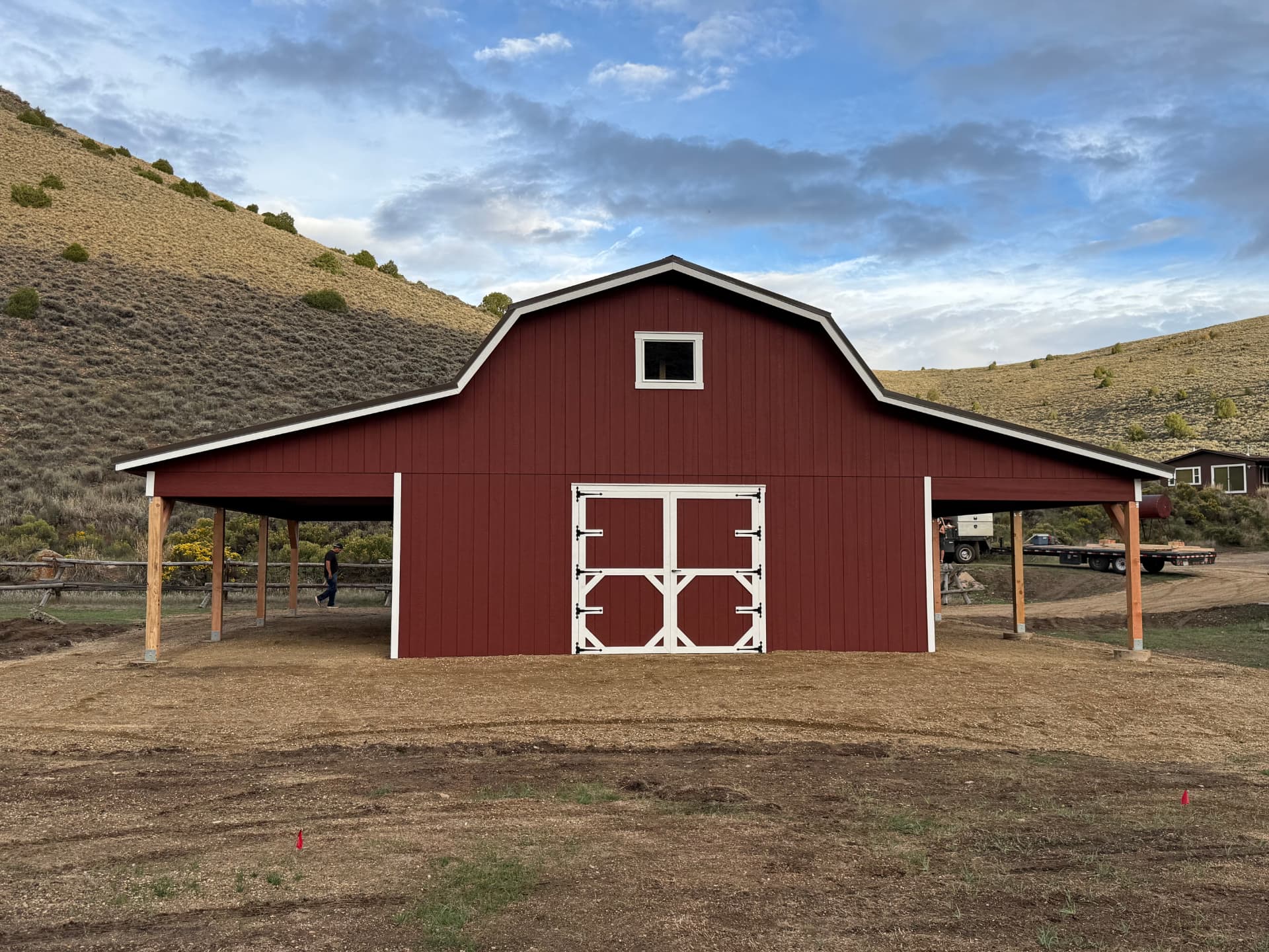 Front of a custom red Hi Wall Barn in Parshall, Colorado with two covered eave overhangs
