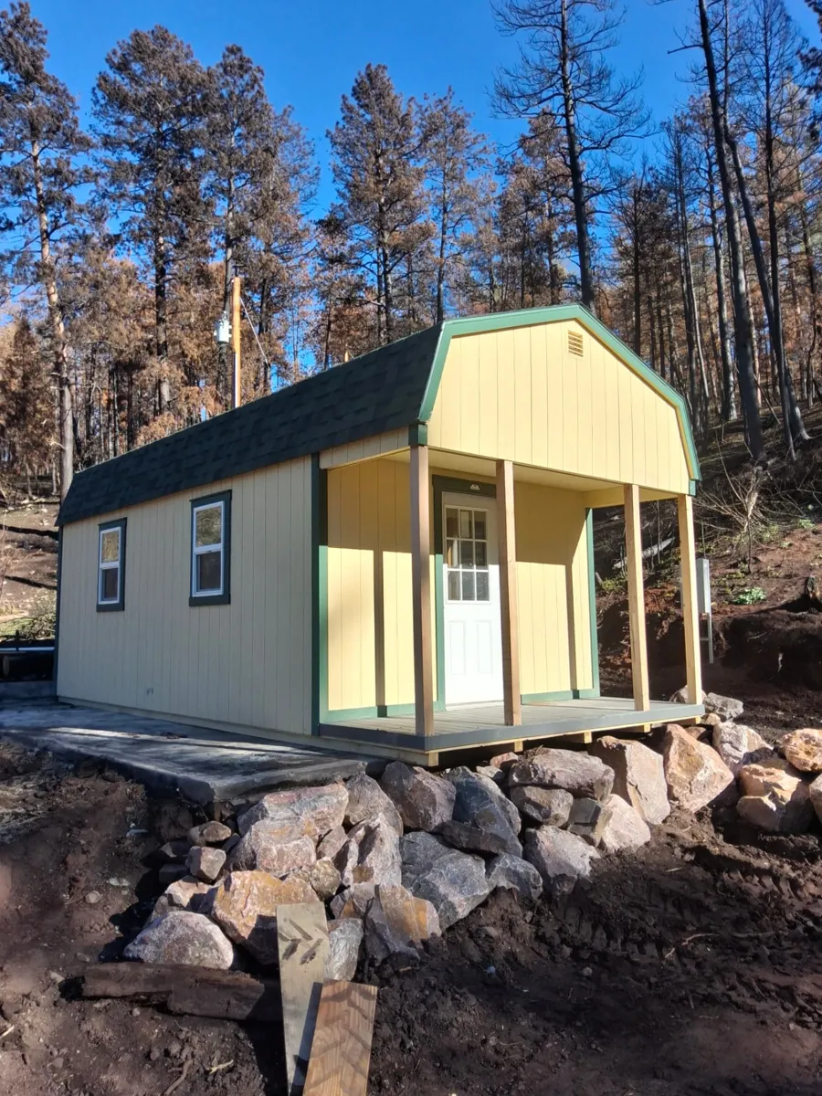 Used 12x24 Hi Wall Barn in Beulah, Colorado, showing the covered porch, cedar posts, 9-lite door and two side windows