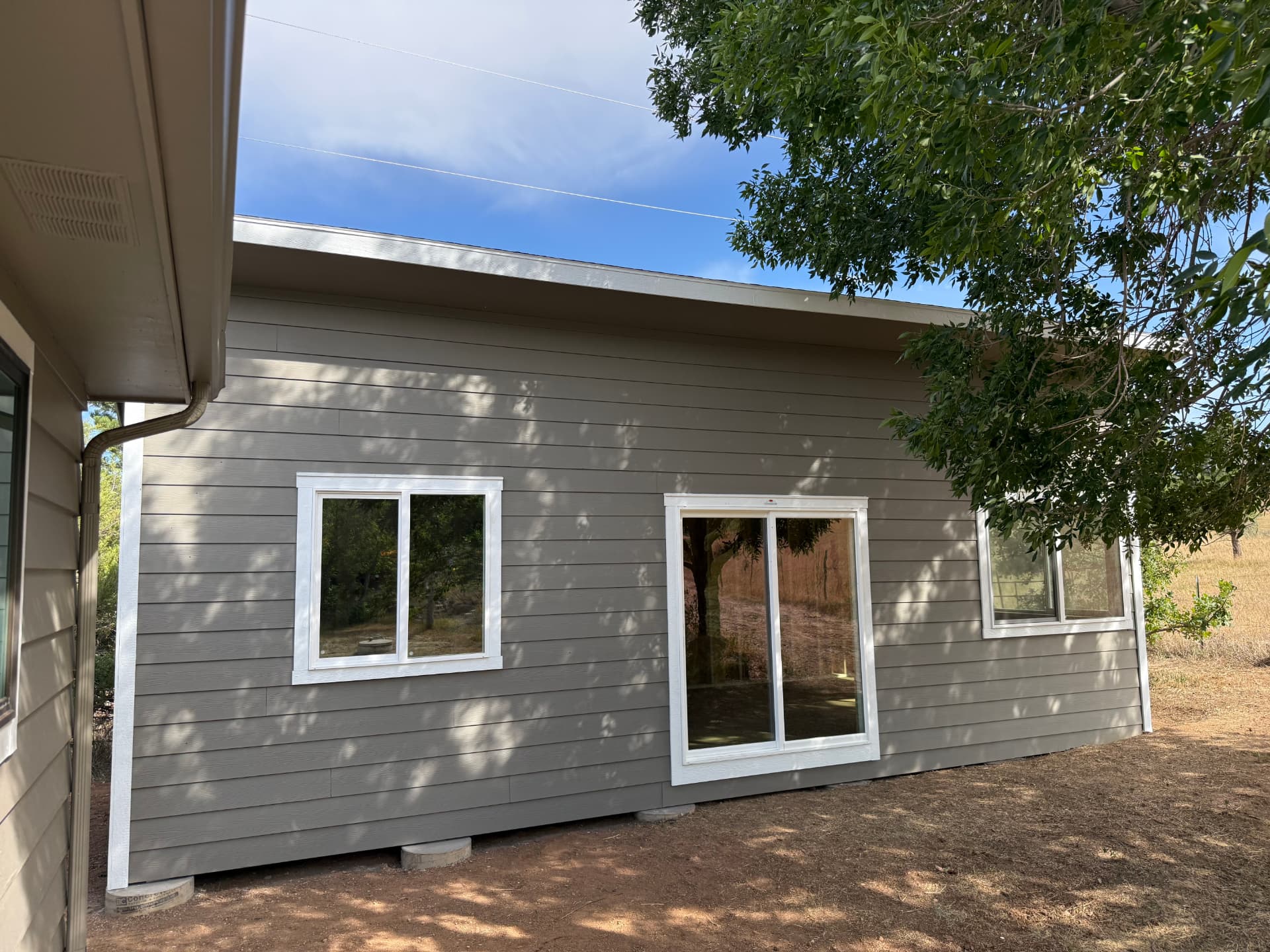 Studio Shed beside a Boulder Colorado home with sliding glass door and windows for a backyard office