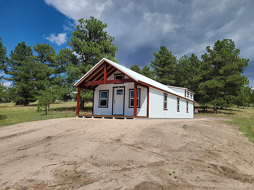 White Cabin shell with red timber porch accents